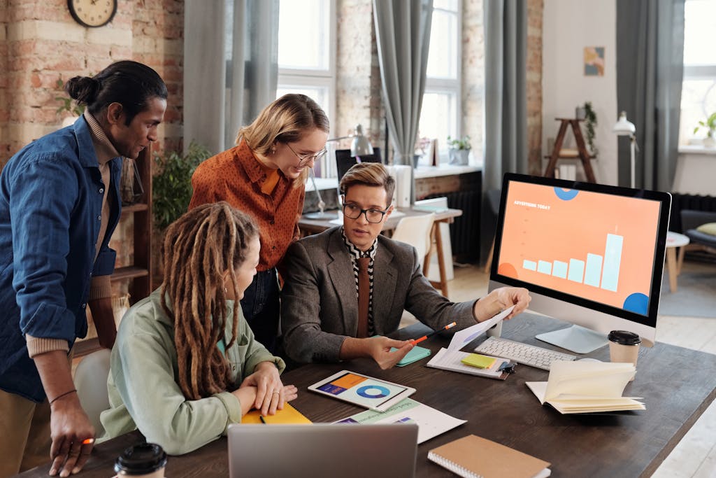 A group of diverse professionals discussing digital marketing plans in a modern office setting.